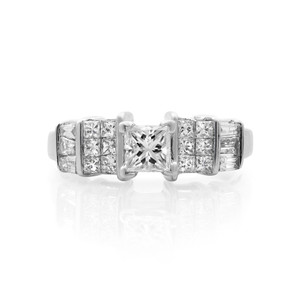 An image of a Rachel Koen women's engagement ring with diamonds, featuring a prominent princess-cut center diamond prong-set in a straight frontal view. Flanked on either side by rows of smaller princess-cut diamonds set into the band with tapered  baguette cut side stones, the ring is presented on a reflective surface, providing a clear, symmetrical view of its detailed design from a close, direct overhead angle.