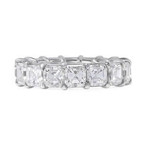 An image of a Rachel Koen women's eternity wedding ring with diamonds, showcased in a front-facing view with a close-up angle. The ring features a series of large, rectangular-cut diamonds set in a band, with the diamonds' facets clearly visible, reflecting light. The setting is a polished platinum, and the ring is centered and occupies the middle of the frame, providing a clear and detailed view of the design and craftsmanship.
