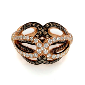 An image of a new Luca Carati women's cocktail ring with diamonds, showcased in a close-up, front-facing view. The ring features an intricate rose gold band with overlapping loops, adorned with multiple rows of sparkling white and brown round cut diamonds in yellow gold. The diamonds vary in color from clear to deep brown, creating a striking contrast. The craftsmanship displays a mix of pave settings, highlighting the ring's elegant curves and angles, which catch the light beautifully.