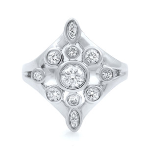 An image of a Rachel Koen brand women's cocktail ring with diamonds, displayed in a close-up, top-down view. The ring features a central round brilliant cut diamond surrounded by smaller round diamonds set in a symmetrical pattern, all mounted on a polished white gold band. The diamonds are positioned to form a geometric floral-like design, and the image is taken from a distance that highlights the sparkle and intricate setting of the stones.