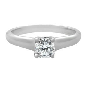 An image of a Tiffany & Co. women's engagement ring with diamonds. The ring is shown in a close-up front view with a focus on the central square-cut diamond that is prong-set on a polished platinum band. The angle of the image provides a clear view of the diamond's facets and the smooth curvature of the ring's band, set against a white background for contrast.