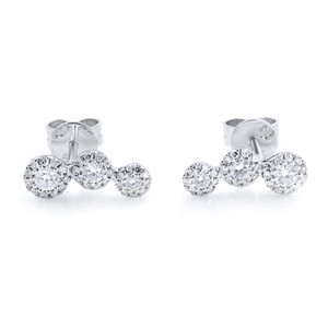 An image of a pair of Rachel Koen brand women's stud earrings with diamonds. The earrings feature a front-facing, close-up view against a white background. Each earring consists of three round, brilliant-cut diamonds set in a linear arrangement, with the largest stone at the base and the smallest at the top, resembling a short vertical bar. The diamonds are set in a white gold, and the earring backs are visible behind the topmost diamonds, suggesting a post closure. The sparkle and facets of the diamonds are clearly visible, and the earrings are positioned parallel to each other, with a slight angle to give depth to the image. The distance between the camera and the earrings is close enough to show the details and craftsmanship while maintaining focus on the entire piece.