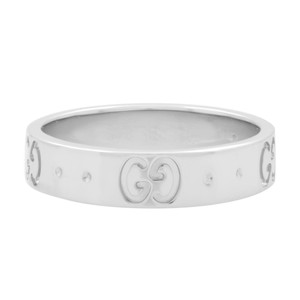 An image of a women's Gucci icon GG ring without stones, shown in a close-up frontal view centered in the frame. The ring features the iconic interlocking "GG" logo embossed at regular intervals around its white gold band, displayed against a white background. The angle of the photograph is direct, with the ring's band running horizontally across the field of view, providing a clear and unobstructed look at the design details.The ring is pre owned in a great condition. 