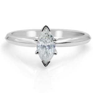An image of a Rachel Koen brand women's engagement ring with diamonds, showcasing a central marquise-cut diamond set in a prong setting, viewed from a front-facing angle that highlights the stone's symmetry. The ring is displayed against a white background with a slight reflection beneath, suggesting a close-up view with emphasis on the diamond and the polished white gold band. The perspective is head-on and at a medium distance, providing a clear view of the ring's design and diamond sparkle.