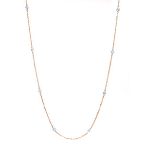 An image of a Rachel Koen brand diamond by the yard women's necklace set in 14k rose gold with white gold bezel setting. The necklace is displayed against a white background and is positioned in a slight S-curve, showing the full length of the chain. The perspective is head-on and the necklace is centered in the frame, providing a clear and detailed view at a medium distance.