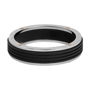 An image of a men's ring without stones from the brand Baraka. The ring is positioned horizontally in the center of the image, viewed from a slight angle above the band. The focus is on the ring's smooth white gold band with center black PVD grooved detailing. The distance captures the ring in full, emphasizing its design details.