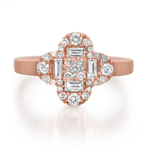 An image of a women's ring by Rachel Koen, featuring a cluster of diamonds set in a rose gold band. The ring is photographed from a front angle at a close distance, showcasing the intricate arrangement of round and baguette-cut diamonds. The central design is symmetrical and prominently displayed, highlighting the sparkle and elegance of the piece.