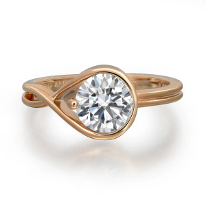 An image of a PANDORA engagement ring for women, featuring a round cut diamond set in a unique, twisted yellow gold band. The ring is photographed from a slightly elevated angle, showcasing the diamond prominently in the center. The photo is taken at a close distance, emphasizing the intricate design and sparkling facets of the diamond against a plain white background.