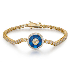 An image of a unisex adult bracelet by Rachel Koen, featuring an elegant design adorned with diamonds and a central blue gemstone in yellow gold. The bracelet is shown from a slightly elevated angle, providing a clear view of its intricate details. The image is taken at a close distance, highlighting the gold setting and the sparkling diamonds encircling the vivid blue center stone.