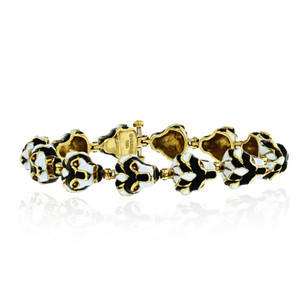 An image of a vintage women's lion head black and white enamel link 18k yellow gold bracelet by David Webb, featuring an intricate design without stones. The bracelet is positioned horizontally, with a slight angle showing both the top and side views. The close-up shot highlights the detailed craftsmanship and color pattern.Excellent pre-owned condition. 