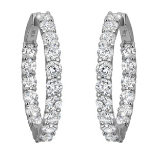 An image of a pair of women's diamond hoop earrings by Rachel Koen. The earrings are shown from the front at a close distance, highlighting their circular shape and the row of sparkling diamonds set in white gold. Each earring is angled slightly inward, emphasizing the brilliance and clarity of the diamonds.