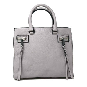 An image of Rebecca Minkoff Medium gray leather ladies satchel handbag, positioned upright and centered. The handbag is viewed from the front at eye level, showcasing its rectangular shape and textured surface. The handles are visible at the top, and there are two decorative zippers with tassels on the front. The background is plain white, and the image is taken at a close distance, highlighting the details of the bag. It has a rub mark on the leather as shown in the picture. It is pre owned excellent condition. 