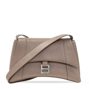 An image features a Balenciaga Treize Medium Ladies Shoulder Bag in dark grey leather. Set upright against a plain white backdrop, the bag is viewed straight on, highlighting its structured design and flap closure. A metallic "B" logo adorns the front. The adjustable shoulder strap is draped diagonally across the bag, enhancing its sleek appearance. The magnetic snap flap closure opens to a main compartment that houses one interior zip pocket and one interior slip pocket. An additional exterior slip pocket and silver-tone hardware complete the design. Crafted in Italy, this bag is in an unworn condition. The dust bag is not included, but it does come with cards. 
