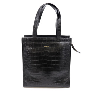 An image showcases a Balenciaga Bazar Medium Shopper Tote Handbag for ladies, crafted from black textured leather. The bag is positioned upright and viewed straight on, highlighting its timeless black hue and top handles, cleverly designed to resemble the Bazar bags seen in markets. A zipper secures the spacious interior, which includes two slip pockets for convenience. The bag is completed with gold-tone hardware and is made in Italy. The handbag is pre-owned and shows minimal wear due to storage and handling, and the dust bag is not included. 