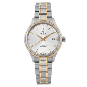 An image of a Tudor Style 38mm men's wristwatch photographed from a straight-on angle at a close distance. The watch features a silver diamond dial with gold hour markers and hands, and a date indicator at the 3 o'clock position. The bezel is gold, and the bracelet is a combination of steel and gold links. The watch is unworn and displays a refined, elegant design.