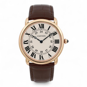 An image of a pre-owned Cartier Ronde Louis 36mm 18K Rose Gold Cream Dial Hand Wind Watch W6800251 positioned upright and facing forward. The watch features a round rose gold case with a cream dial, displaying large black Roman numerals and smaller 24-hour markers. The hands are elegant and black, contrasting with the dial. The crown is adorned with a dark cabochon. The brown leather strap is visible and appears slightly curved. The angle is straight-on, providing a clear view of the watch face, captured at a close distance.