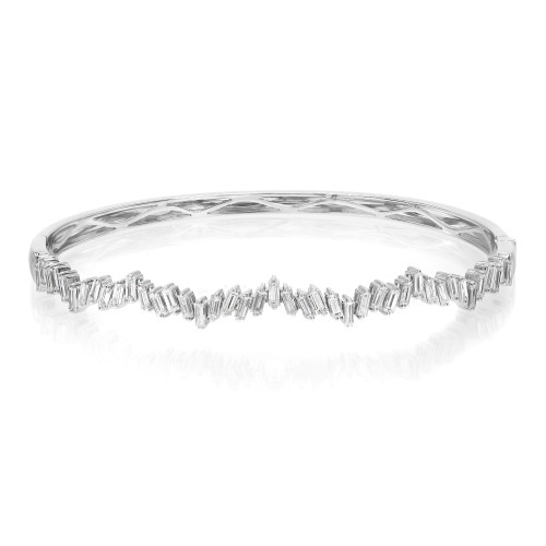 An image of a Rachel Koen women's bracelet with diamonds, presented in a front-facing view centered horizontally on a white background. The bracelet features a series of sparkling, baguette-cut diamonds set in a continuous zig zag line along the band. The diamonds are arranged edge-to-edge around the entirety of the bracelet, which is shown in a slight perspective that gives depth to the image, with the front of the bracelet appearing closer and the sides gently receding. The bracelet is made in highly polished white gold, reflecting light and emphasizing the clarity and shine of the diamonds.