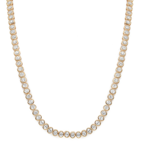 An image of a Rachel Koen women's tennis necklace with diamonds, displayed against a white background. The necklace features a single row of bezel set oval cut diamonds, each set in yellow gold. The necklace is laid out in a slight curve from the top left to the bottom right of the frame, allowing the entirety of the piece to be visible. The perspective is a top-down view, and the necklace is presented at a close distance to capture the sparkle and detail of the diamonds.