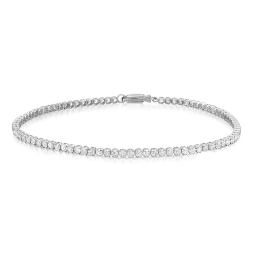 An image of a Rachel Koen brand unisex adult tennis bracelet with diamonds, presented in a close-up, frontal view on a white background. The bracelet forms a nearly complete circle with the front facing upwards, showcasing a continuous row of sparkling diamonds set in white gold band. The clasp is visible at the top, slightly off-center, indicating the opening of the bracelet. The diamonds are arranged in a single line, capturing the light and emphasizing their brilliance. The image is taken from a distance that allows the entire bracelet to be visible, focusing on the detail and craftsmanship of the piece.