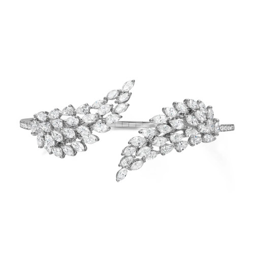 An image of a Messika women's Angel Double Diamond open 18k white gold bracelet with diamonds, displayed against a white background. The bracelet features an intricate design with two leaf-like structures adorned with multiple marquise-cut diamonds, creating a sparkling effect. The bracelet is positioned horizontally in the center of the frame with the diamond details facing the viewer, offering a clear view of the craftsmanship and stone setting from a top-down angle. The distance from the camera provides a full view of the piece, allowing the intricate details and overall shape to be appreciated.