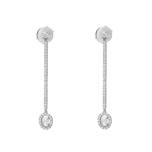 An image of a pair of Messika women's Pend Glam'Azone drop 18k white gold earrings with diamonds, presented on a white background. The earrings are vertically aligned and positioned at equal distances from the center. They feature a linear drop design with a series of small, round-cut diamonds set along their length, terminating in a larger, round diamond encircled by a halo of smaller diamonds. The view is head-on, showing the earrings in their full, sparkling detail.