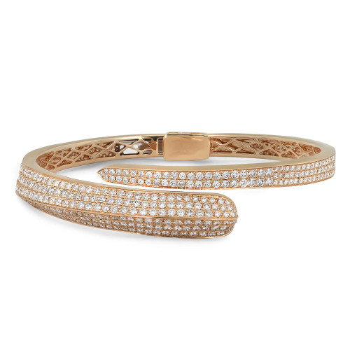 An image of a Rachel Koen women's bangle bracelet with diamonds, displayed in a close-up side view with a slight angle to show depth. The bracelet features two rows of sparkling diamonds set in a polished yellow gold spiral open band, with intricate cut-out detailing visible on the inner side. The clasp is centered and prominently displayed, engraved with the brand's name. The bracelet is positioned against a white background, highlighting its elegance and craftsmanship.