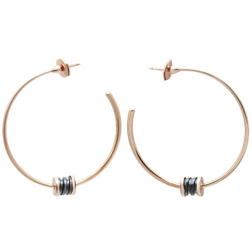 An image of a pair of Bvlgari B.Zero1 Ceramic hoop earrings for women, displayed against a white background. The earrings are crafted in rose gold and feature a simple, elegant design without any gemstones. Each earring has a set of black ceramic rings near the bottom, which add a subtle decorative accent. The earrings are shown in a front-facing position, with one earring slightly overlapping the other, creating a sense of depth. The photograph is taken from a medium distance, allowing clear visibility of the earrings' design and details. The condition of the earrings are new. 