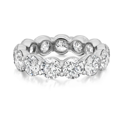 An image of a Rachel Koen women's eternity band ring with lab grown diamonds, displayed in close-up. The ring features multiple round cut diamonds set in a shared prong setting in white gold, which provides a full view of the stones and their facets. It is captured from a top-down angle, showing the circular pattern of the diamonds and reflecting light, with a slight tilt to give depth to the arrangement of the stones. The white gold band is polished to a high shine, complementing the brilliance of the diamonds. The image is taken from a distance close enough to reveal the intricate details of the ring's design and craftsmanship.