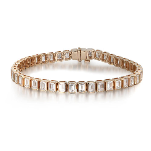 An image of a Rachel Koen brand unisex adult tennis bracelet with lab grown diamonds, showcased in a straight line at a slight angle to the viewer. The bracelet features a series of emerald-cut diamonds encased in bezel settings in yellow gold, reflecting light with a warm glow. The piece is centered and occupies the middle portion of the frame, providing a clear view of its elegant design. The clasp is visible at the top and appears to be a seamless part of the bracelet's design. The background is a neutral, light color, ensuring the focus remains on the jewelry's craftsmanship and sparkle.
