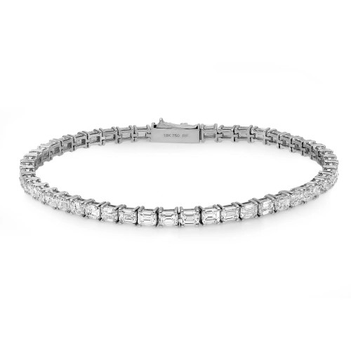 An image of a Rachel Koen unisex adult bracelet with diamonds, shown in a straight line from a top-down view. The bracelet features a series of evenly spaced, clear, emerald-cut diamonds set in a polished white gold bracelet. The clasp and hallmark are visible on the nearest end, indicating 18K gold. The image is taken from a close distance, ensuring the diamonds and design details are in focus and clearly visible.