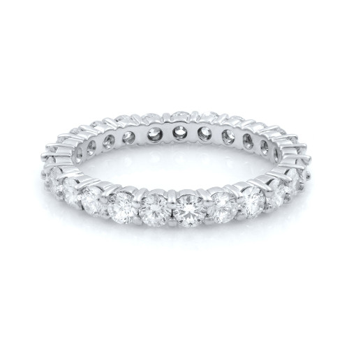 An image of a women's Rachel Koen brand eternity ring with diamonds, displayed in a close-up frontal view against a white background. The ring features a full eternity design with round brilliant-cut diamonds set in a shared prong setting, encircling the entire white gold band. The metal's high polish is visible, reflecting light and accentuating the diamonds' sparkle.