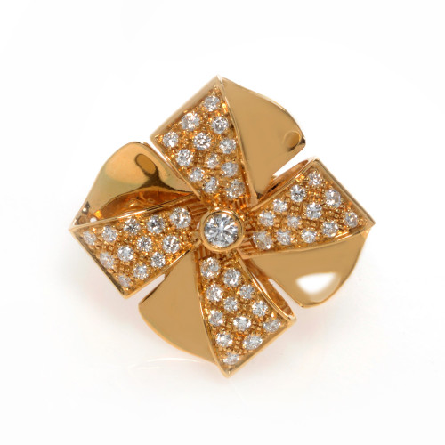 An image of a new Luca Carati women's cocktail ring with diamonds, photographed from above at a close distance, showing a top view that highlights the ring's intricate design. The ring is made in yellow gold and features a large, flower-like setting with multiple petals, each encrusted with small, sparkling round cut diamonds. At the center of the flower, there is a prominent, larger round diamond that serves as the focal point. The overall appearance is luxurious and ornate, with a warm golden hue and the reflective quality of the diamonds providing a shimmering effect.