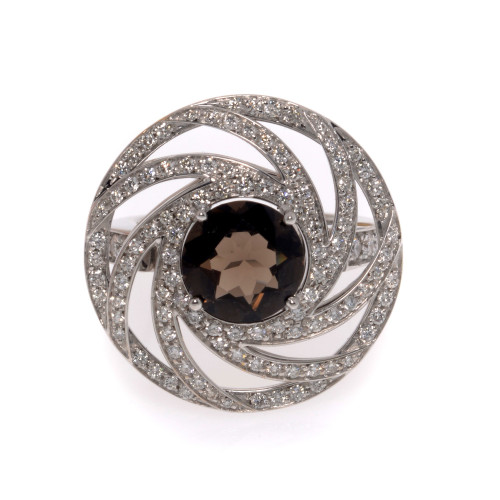 An image of a new Luca Carati women's cocktail ring featuring a large central smoky quartz gemstone surrounded by concentric circles of small round cut diamonds in white gold. The view is a direct overhead shot, showing the ring's intricate design and the sparkle of the gemstones on a neutral background. The distance is close-up, providing a clear view of the ring's details and craftsmanship.