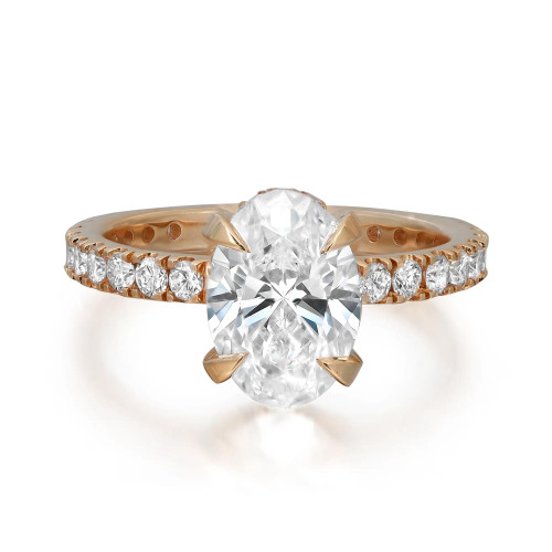 An image of a Rachel Koen brand engagement ring for women, featuring a prominent oval-shaped lab grown diamond set in the center with a halo of smaller lab grown round diamonds encircling the band. The ring is presented in a close-up view against a white background, with the yellow gold band angled slightly to the left, allowing the diamonds to catch the light and showcase their brilliance. The yellow gold band has a polished finish that complements the sparkle of the lab grown diamonds.