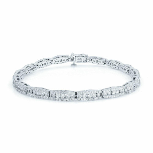 An image of a Rachel Koen women's tennis bracelet with diamonds, shown from a front-facing angle. The bracelet is displayed against a white background and is positioned horizontally across the frame. It features multiple rows of sparkling diamonds, meticulously set within a polished white gold band. The clasp is visible and located at the top center of the bracelet, indicating it is designed to be worn with the clasp at the underside of the wrist. The photograph is taken from a close distance, capturing the intricate details and reflections of the diamonds and metalwork.