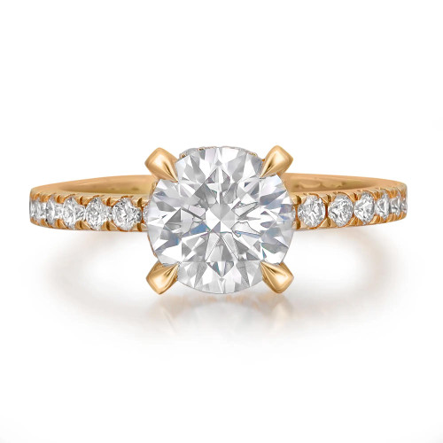 An image of a Rachel Koen women's engagement ring with diamonds, showcased in close-up and centered view against a white background. The ring features a large, round-cut central lab grown diamond held by four prongs, with smaller round-cut lab grown diamonds encrusting over half of the yellow gold band. The band curves gently towards the right, with the diamonds catching the light at various angles, highlighting their brilliance and the ring's elegant design.