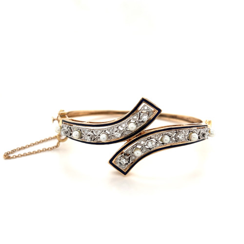 An image of a women's vintage yellow gold bracelet designed by Rachel Koen, featuring diamonds and pearls. The bracelet is elegantly displayed at a slight angle, close-up, showcasing its intricate design. Two overlapping bands adorned with diamonds and pearls are prominently visible, with a delicate chain attached on the left side. The background is a clean white, emphasizing the luxurious details of the jewelry.Excellent pre-owned condition. 