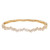An image of a Rachel Koen women's bracelet with diamonds displayed horizontally against a white background. The bracelet is in sharp focus, showcasing a series of shimmering, baguette-cut diamonds arranged in a zigzag pattern along the top half. The yellow gold band of the bracelet has a smooth, polished finish with geometric cut-out designs visible on the underside. The view is from a top-down perspective, capturing the jewelry piece from a close, but ample distance to appreciate its full design and luxurious appearance.