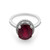 An image of a Rachel Koen women's ring with a large oval-cut red Ruby at the center, flanked by a halo of small diamonds. The ring is viewed from a top angle, showcasing the ruby's facets and the diamonds' sparkle. The band is 14k white gold, and the ring is positioned directly facing the camera at a close distance, on a white background. The condition of the ring is pre owned. 