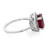 An image of a Rachel Koen women's ring featuring a prominent oval red ruby set in a white gold band, viewed from a side angle. The band is adorned with small diamonds along the side leading up to the ruby. The ring is positioned against a white background, with the focus on the ruby and the upper half of the band, providing a clear view of the intricate setting and the sparkle of the diamonds.The condition of the ring is pre owned. 