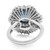 An image of a Rachel Koen women's ring, displayed at a close-up angle that highlights the top view. The intricate design features a circular array of 14k white gold spokes converging towards a central blue sapphire, flanked by smaller diamonds. The craftsmanship provides a three-dimensional effect, emphasizing the sparkle and depth of the gemstones. The ring band is visible in the foreground, completing the elegant structure of the piece.