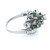 An image of a Rachel Koen women's cocktail ring with diamonds and green emeralds . The ring is shown in a close-up side view with a slight angle that highlights the intricate design. The band is platinum and polished, with a cluster of sparkling diamonds and rich green emeralds set at the top. The diamonds and green emeralds are arranged in a detailed pattern, reflecting light from various angles. The background is pure white, emphasizing the jewelry's details and craftsmanship.