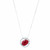 An image of a Rachel Koen women's pendant necklace featuring a large, central oval red Ruby surrounded by a halo of smaller diamonds. The pendant is displayed at a direct front view with the necklace chain symmetrically extending upwards on both sides. The background is 14k white white, providing high contrast that accentuates the jewelry's sparkle and color. The necklace is photographed from a medium distance allowing clear visibility of the gemstone facets and the intricate details of the setting.