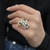 Front view on model finger of the estate cocktail ring with prong set oval cut white opal and blue sapphire studded in a yellow gold ring mounting