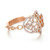 An image of a luxurious Messika women's ring with diamonds, displayed at a slight angle to showcase the intricate design. The ring features a rose gold band with a large, ornate, openwork diamond-encrusted motif that resembles a stylized floral or geometric pattern. The ring is positioned against a white background, with the band extending from the bottom left to the top right of the frame, providing a clear view of the sparkling diamonds and the detailed craftsmanship.