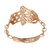 An image of a women's Messika ring with diamonds, displayed at a slight angle to showcase its design. The ring features a unique openwork pattern on the upper half, resembling a delicate filigree in rose gold. A small, solitary diamond is embedded on the lower half of the band, which is engraved with the Messika logo. The band connects to the patterned section with small, polished rose gold links. The image is taken from a close distance, providing a clear view of the ring's intricate details and the sparkle of the diamond.