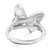 An image of a women's Messika ring with diamonds, displayed at a three-quarter angle to showcase the band and the setting. The ring features a prominent, butterfly-shaped design with diamond detailing, positioned centrally and viewed from a slightly elevated perspective. The band appears smooth and polished, curving to form the base of the butterfly, which is rendered in a clear, shining metal. The distance from the camera provides a close-up view that captures the brilliance and intricate craftsmanship of the piece.