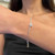An image of a Messika women's bracelet with diamonds, positioned on a woman's wrist at a close-up angle. The bracelet features a delicate chain with a circular diamond centerpiece, which is in focus and located centrally on the wrist. The background is blurred to highlight the intricate design of the jewelry.