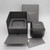 An image of a Messika branded packaging set for a women's ring with diamonds, although the ring itself is not visible. The set includes a dark grey outer box with the brand's name, a hexagonal ring box with a lid slightly ajar, and a drawer-style presentation box opened to reveal a hexagonal impression where the ring would typically be displayed. All items are positioned against a white background, captured from a top-down angle with the camera focused on the center of the composition.