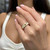 An image of a woman's hand showcasing a Messika Spiky Diamond band ring. The ring is positioned on the ring finger, presented in close-up with a slight tilt towards the camera, emphasizing the sparkle of the diamonds. The hand is at a medium distance from the camera, with the focus on the ring, creating a blurred background that accentuates the jewelry's details.